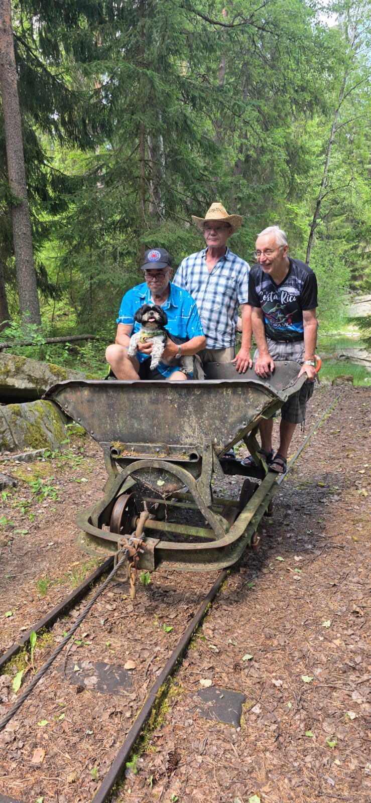 Drei AKL-Mitglieder mit kleinem Hund an der historischen Lore im Schausteinbruch Häuselloh