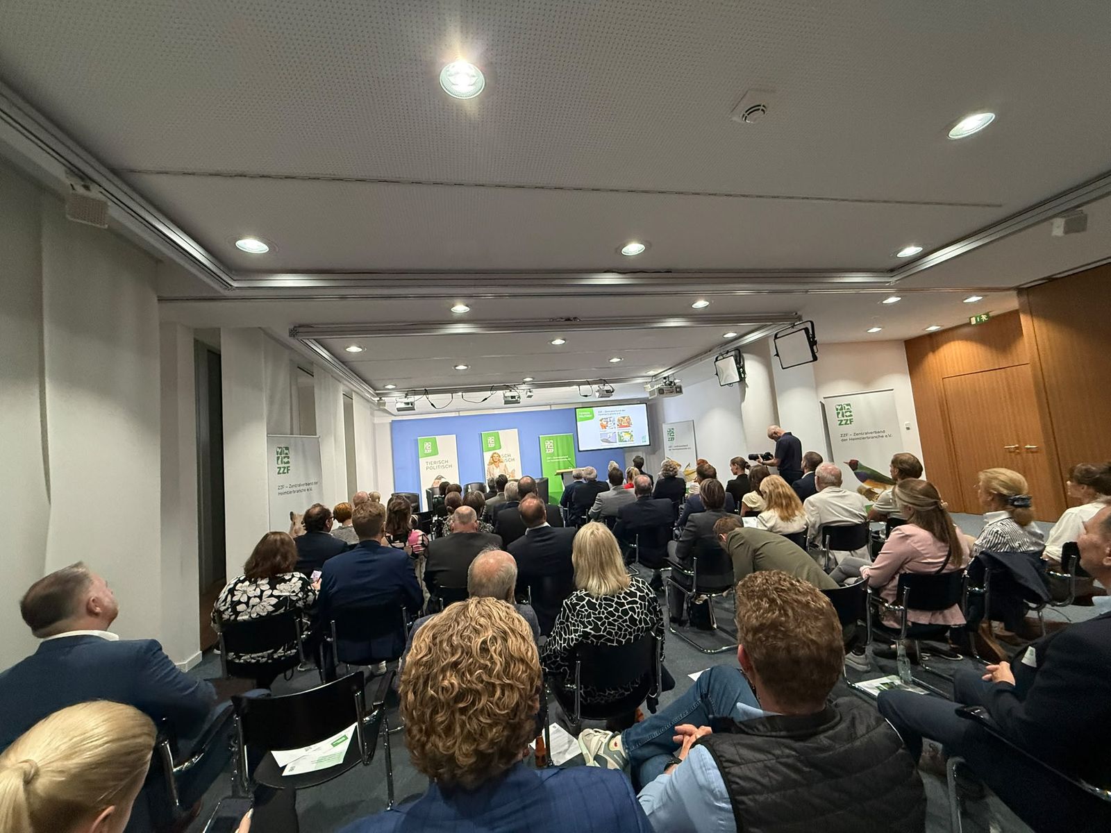 Voll besetzter Saal mit Publikum vor der Bühne, seitlich ZZF-Banner mit dem Motto Tierisch politisch
