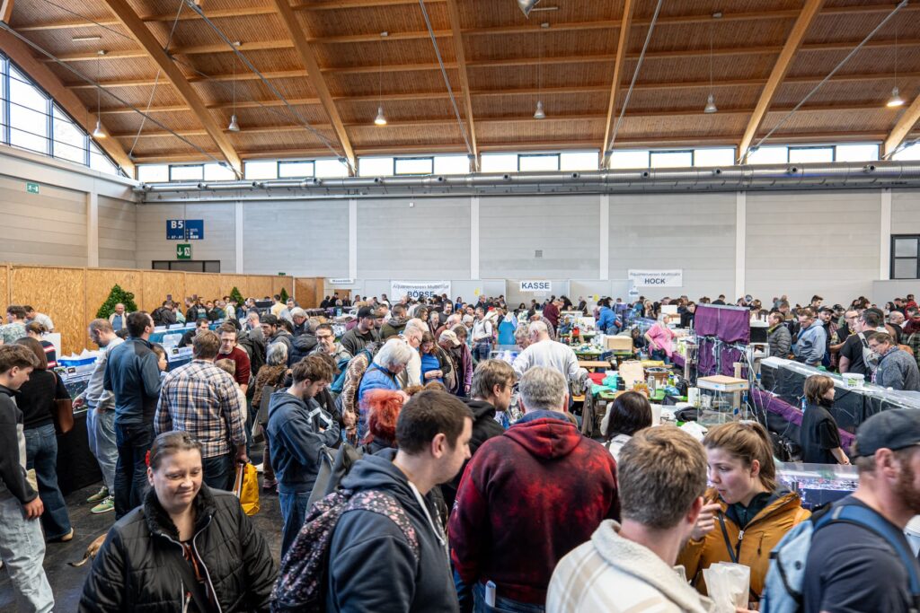 Volle Messehalle mit vielen Besucherinnen und Besuchern an Ausstellungstischen